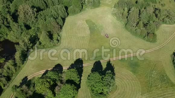 红色拖拉机在草地上割草空中视频的预览图