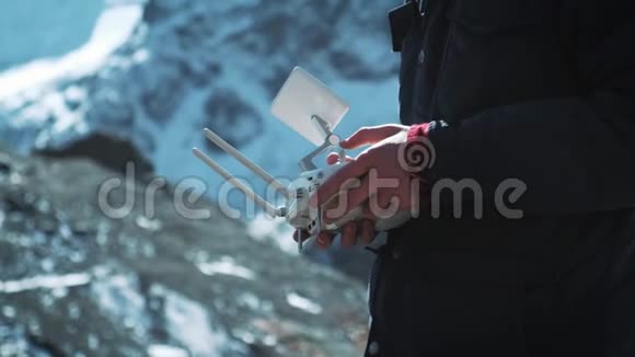 无人机遥控无人机飞行员操作员的手和远程视图雪山上的旅行者视频的预览图