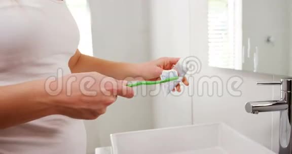 女洗牙刷在浴室洗手池的中间部分视频的预览图