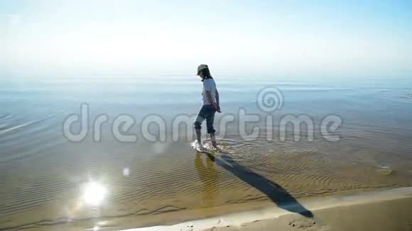 女孩走在干净的金色沙滩上视频的预览图