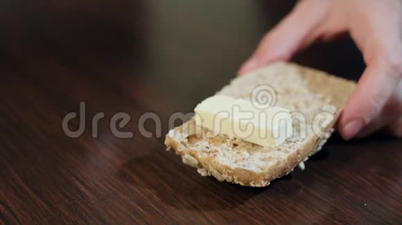 女性手在面包上传播黄油视频的预览图