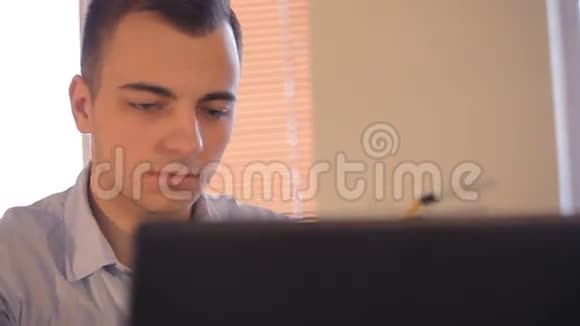 在办公室的笔记本电脑上做生意的年轻人视频的预览图