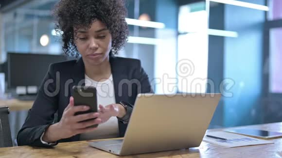 严肃的女商人在工作中使用智能手机视频的预览图