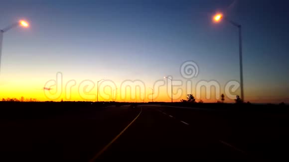 日出时分驱车行驶在乡村公路上清晨太阳升起时驾驶员视角视频的预览图