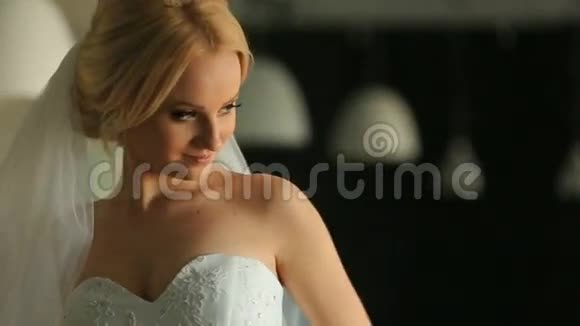 华丽俏皮的金发新娘身穿白色礼服在餐厅背景摆姿势视频的预览图