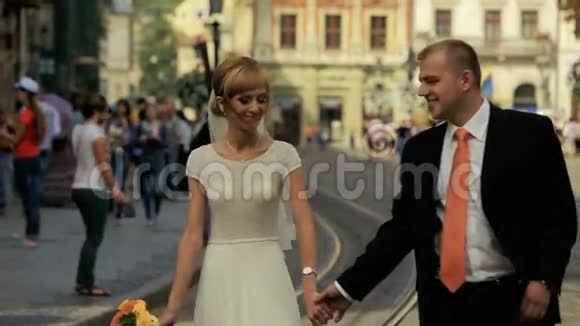 幸福的新婚夫妇走在古城街道上美丽的建筑视频的预览图