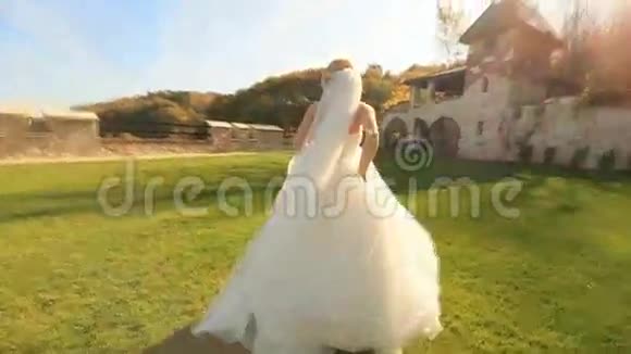 中世纪城堡庭院里一位身穿白色连衣裙的金发美女的动态视频视频的预览图