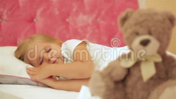 可爱的小女孩睡在她的玩具熊旁边视频的预览图