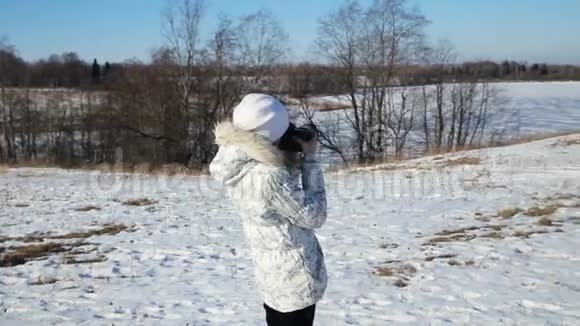冬天公园里的女孩拿着相机拍照视频的预览图