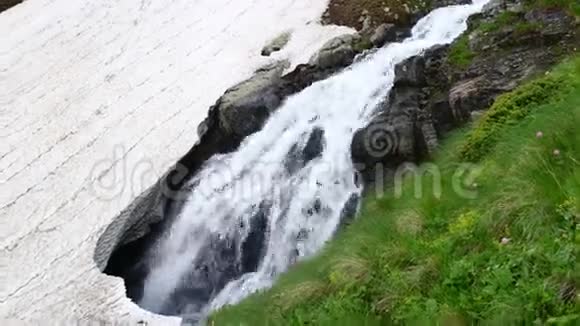 山瀑布在冰下流淌春天冰川融化视频的预览图