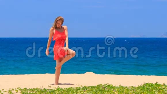 金发女郎赤着脚在沙滩上跳舞穿着时髦的裙子视频的预览图