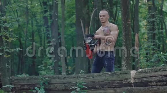强壮的伐木工人用电锯锯树慢慢地视频的预览图