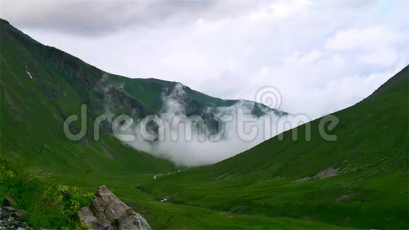 在卡夫卡兹地区的高山绿谷上空雾和云的时间流逝视频的预览图