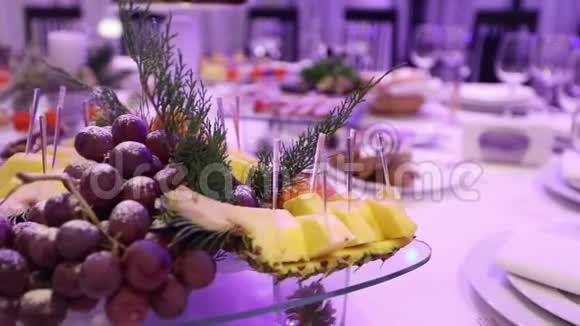 餐厅宴会桌上的水果和食物宴会桌上的菠萝和一束葡萄视频的预览图