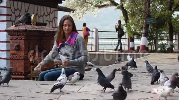 在尼泊尔寺庙喂鸽子的女人视频的预览图