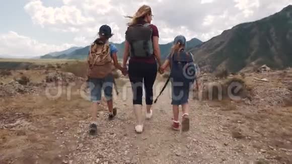 全家游客一个年轻的女人带着孩子走在山上的一条小路上年轻的母亲和孩子视频的预览图