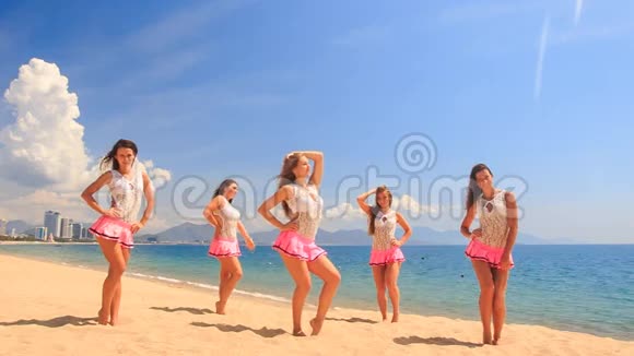 啦啦队员舞蹈表演各种姿势的沙滩对海视频的预览图