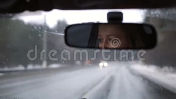 女孩在后视镜中驾驶汽车的反映视频的预览图