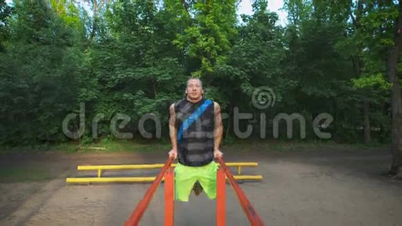 肌肉男在公园锻炼唇锻炼胸部和肱三头肌视频的预览图