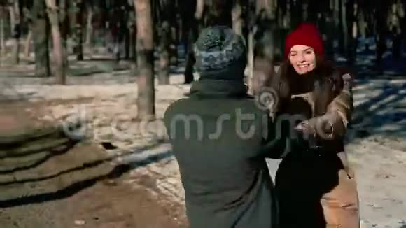 两个年轻人在雪地里的树林里笑视频的预览图