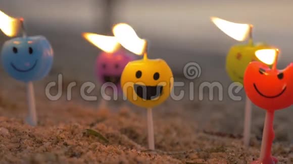 海滩上五颜六色的笑脸蜡烛视频的预览图