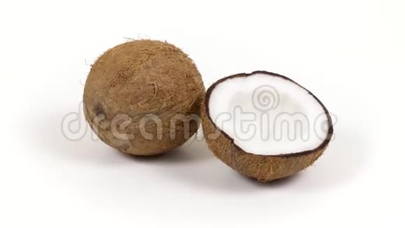 整个椰子和一半与美味的果肉旋转在白色孤立的背景可循环无缝可可视频的预览图