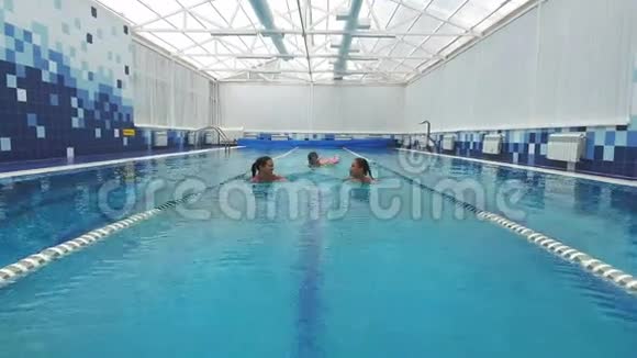 三个快乐的朋友在游泳池里游泳和聊天视频的预览图