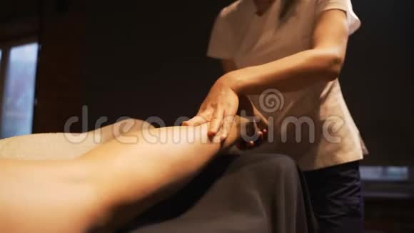年轻女子在美容院做脚部按摩关门玛瑟揉捏一个年轻漂亮女孩的脚和腿视频的预览图