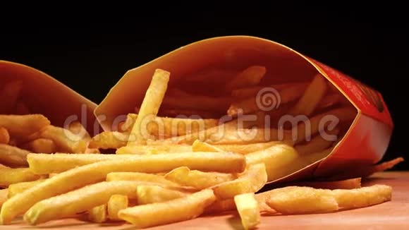 纸盒加薯条流行快餐油炸土豆4在黑色背景下拍摄的特写镜头视频的预览图