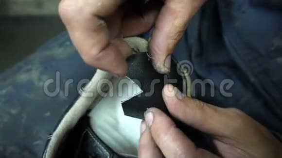 鞋匠把一块黑色的皮贴在运动鞋上视频的预览图