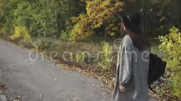 戴着黑帽子戴着眼镜走在秋街上的年轻美女视频的预览图