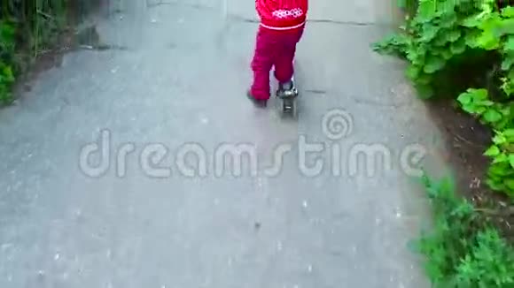 女孩骑着滑板车在沥青路上视频的预览图