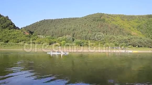 一家人带着小独木舟在平静的河流上视频的预览图