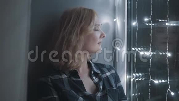 美丽迷人的女人坐在窗台上装饰着加兰新年圣诞节假日概念视频的预览图