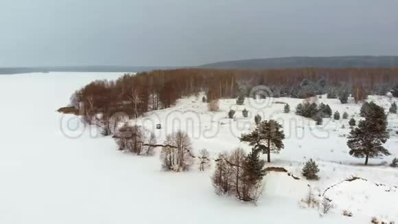 雪中一条冰冻河流的空中俯视图空中冬季景观直升机射击视频的预览图