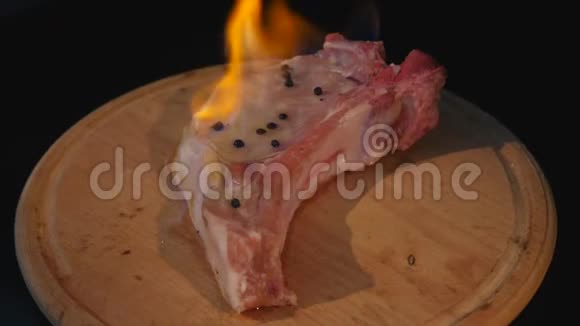 火中生肉在砧板上旋转的特写镜头视频的预览图