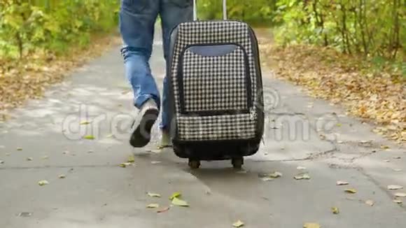 提着手提箱走在人行道上的人视频的预览图