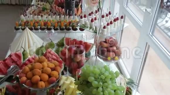 为婚宴提供桌上的美味糖果和水果餐厅提供鸡尾酒派对视频的预览图