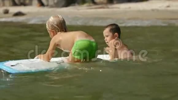 幼儿在玩海上冲浪并在水中慢动作视频的预览图