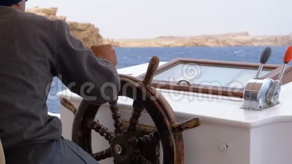 坐在游艇方向盘上的船长船长控制游艇视频的预览图