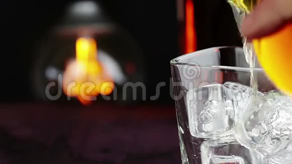 酒吧服务员在木桌上倒满冰块的威士忌温暖的气氛用威士忌放松的时间和一些温暖的老式灯泡视频的预览图