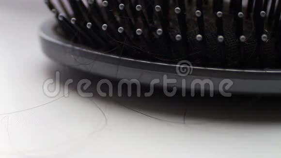 女性梳头发刷与头发极端宏观特写镜头近黑色发夹视频的预览图