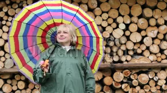 穿绿色光滑衣服的女人站在木材旁边微笑着视频的预览图
