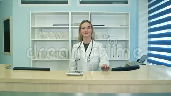 微笑的女医生在接待处看着镜头视频的预览图