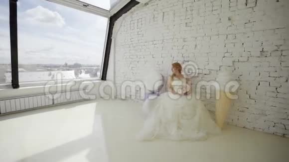 可爱的金发女郎穿着婚纱在工作室摆着巨大的冰淇淋视频的预览图
