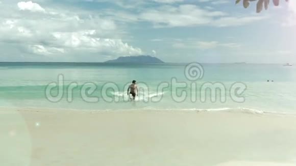 塞舌尔海滩上的快乐男人从海里出来视频的预览图