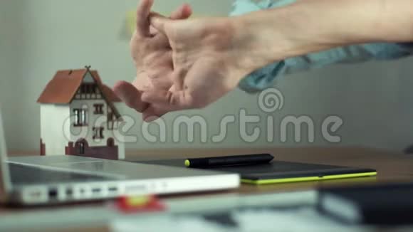 创意平面设计师在工作前用手提电脑捏手指视频的预览图