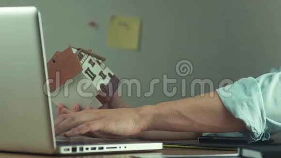 年轻建筑师在手提电脑上建造房屋项目视频的预览图