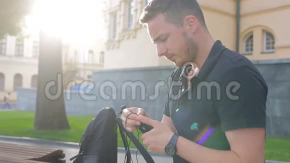 快乐的男人在城市的智能手机上听音乐视频的预览图