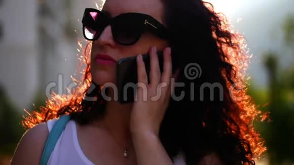 漂亮的女人在户外打电话一位年轻的母亲在街上说话戴眼镜的女人慢慢视频的预览图